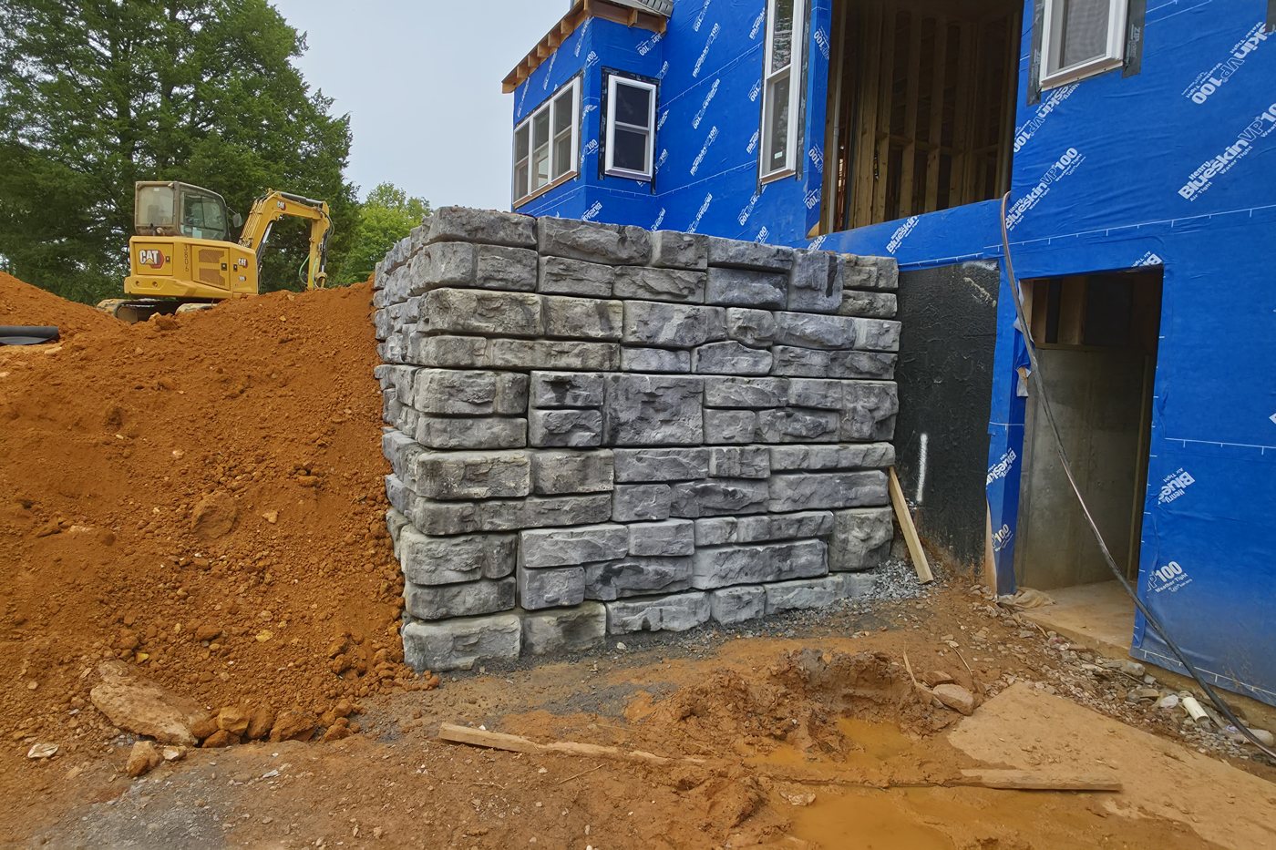 Finished L-shaped Redi-Rock gravity retaining wall, 12-foot and 8-foot legs, about 8 feet tall, beside the walkout basement door, Gainesboro TN