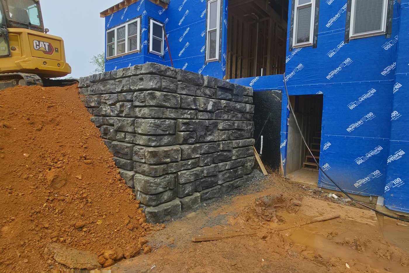 The same Redi-Rock retaining wall after rain, a darker charcoal gray, Gainesboro TN